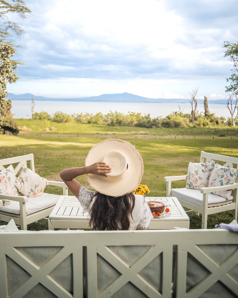 Guest reclining on a lounge sofa reaching for a cocktail on a low round table