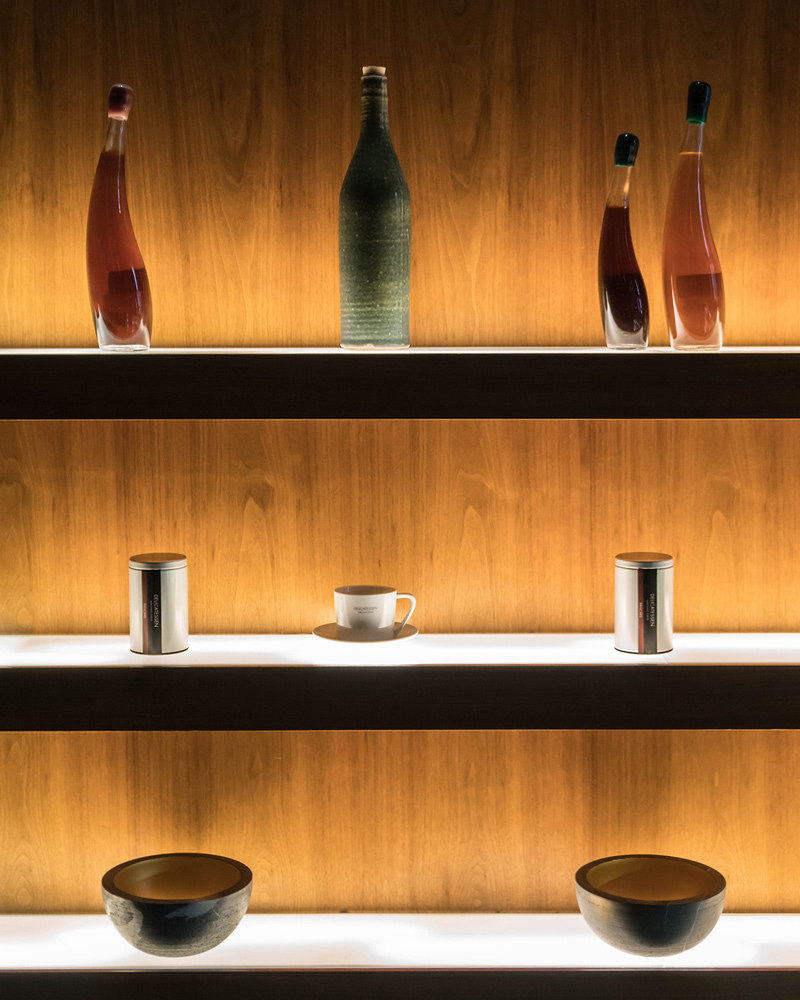 Guest reclining on a lounge sofa reaching for a cocktail on a low round table