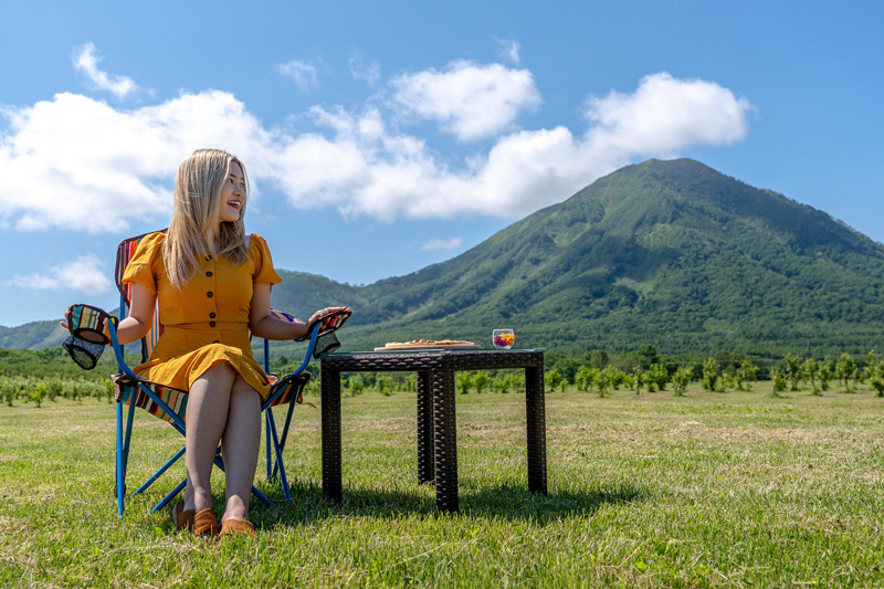 Guest in a yellow dress at an outdoor table with a mountain backdrop