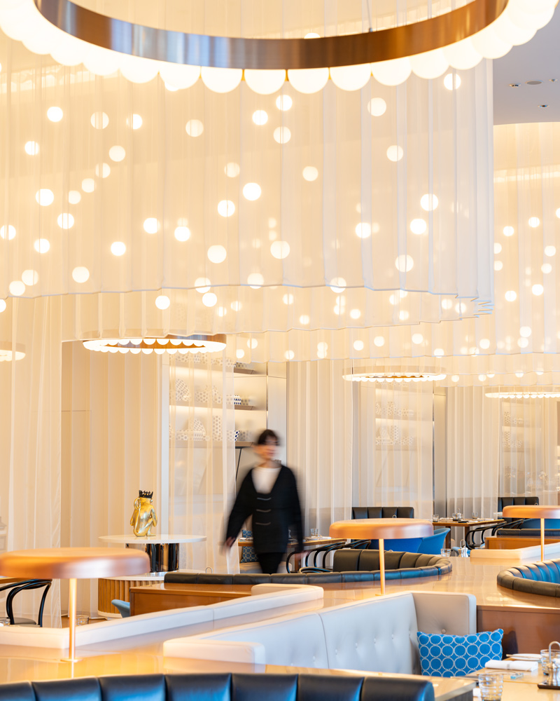 W Osaka hotel restaurant with a sculptural ring chandelier and blue booth seating