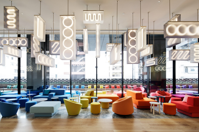 Colorful lounge seating area with hanging geometric light fixtures